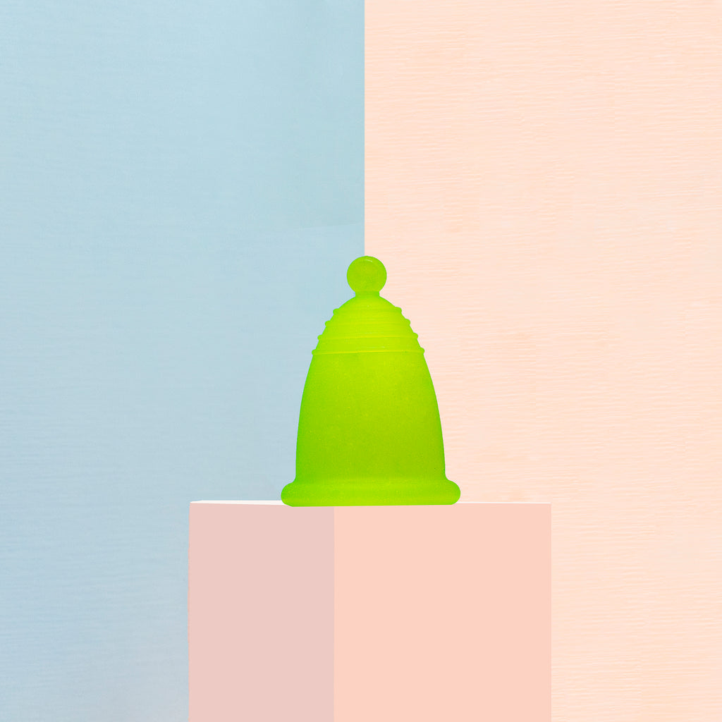 Una copa menstrual verde en tallas especiales: chica, mediana y grande